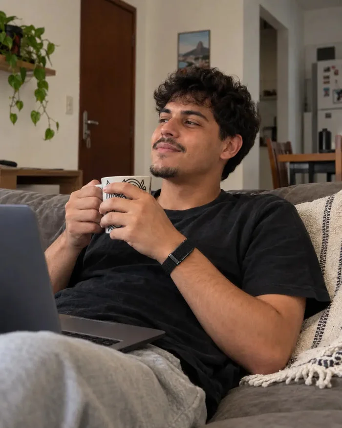 Homem relaxando no sofá com a eaze no pulso